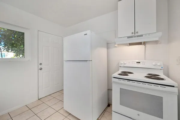 a kitchen with white cabinets and white appliances