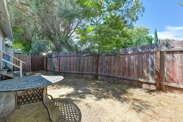 a backyard of a house with table and chairs
