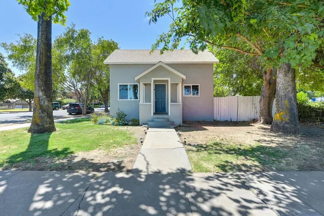 a front view of a house with a yard and trees
