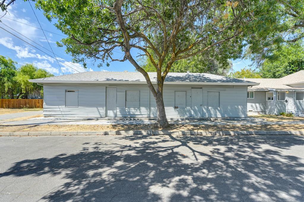 205 North Shasta Street Willows, CA 95988 - Photo 9 of 32 a backyard of a house with table and chairs under an umbrella