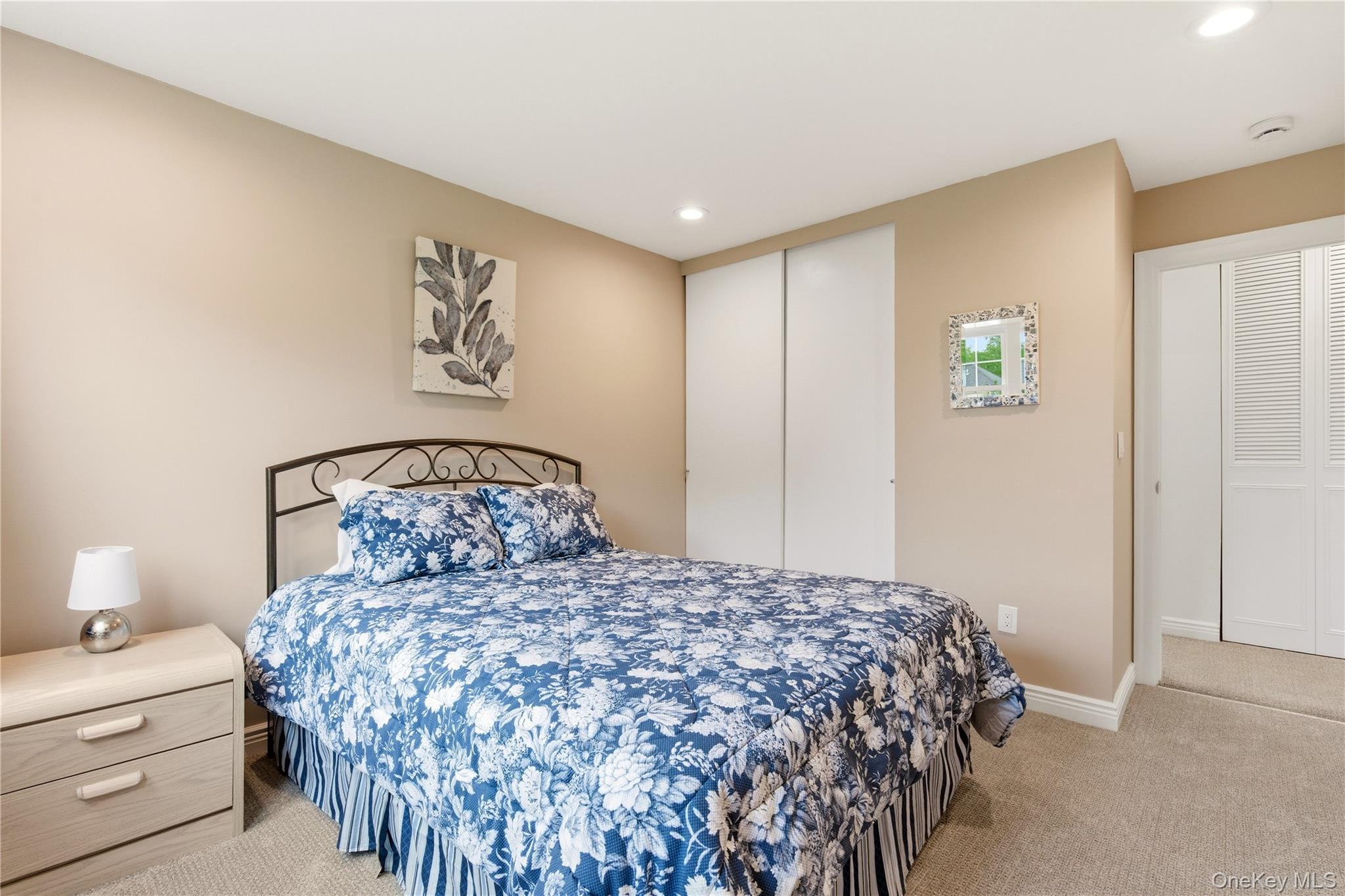 44 Hidden Ridge Drive Syosset, NY 11791 - Photo 16 of 28 a bedroom with a large bed and a lamp on dresser