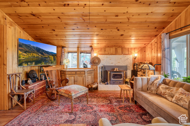 714 Spotted Fawn Way Kamas, UT 84036 - Photo 7 of 34 Living area featuring wood walls, a wood stove, wooden ceiling, and wood finished floors