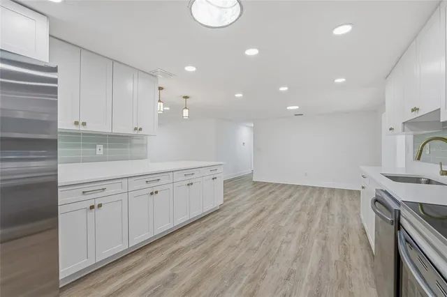 a kitchen with granite countertop white cabinets and white appliances
