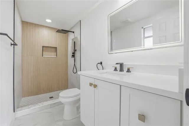 a bathroom with a sink a toilet and a mirror