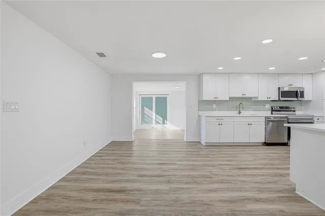 a kitchen with granite countertop a stove top oven sink and cabinets