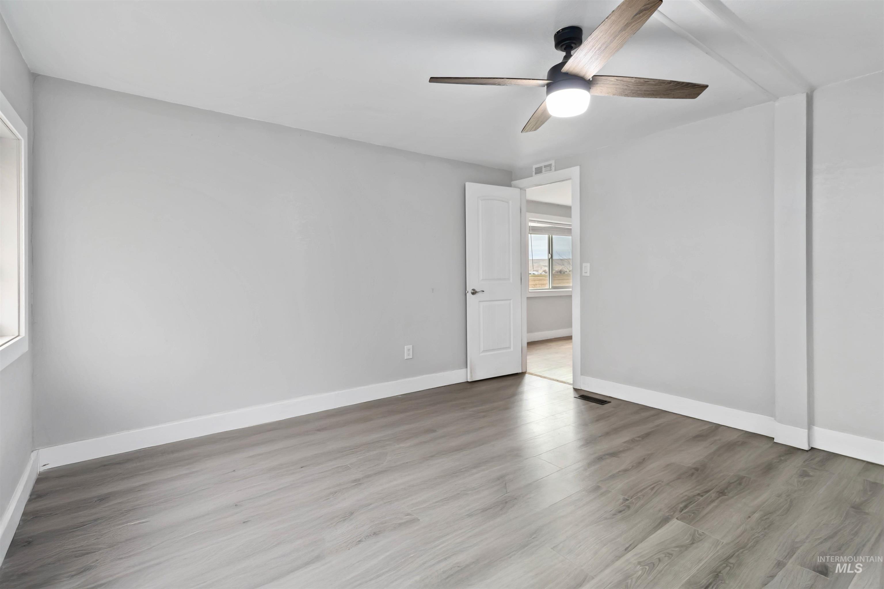 5827 East Little Basin Road King Hill, ID 83633 - Photo 14 of 47 Empty room with light wood-style flooring and ceiling fan