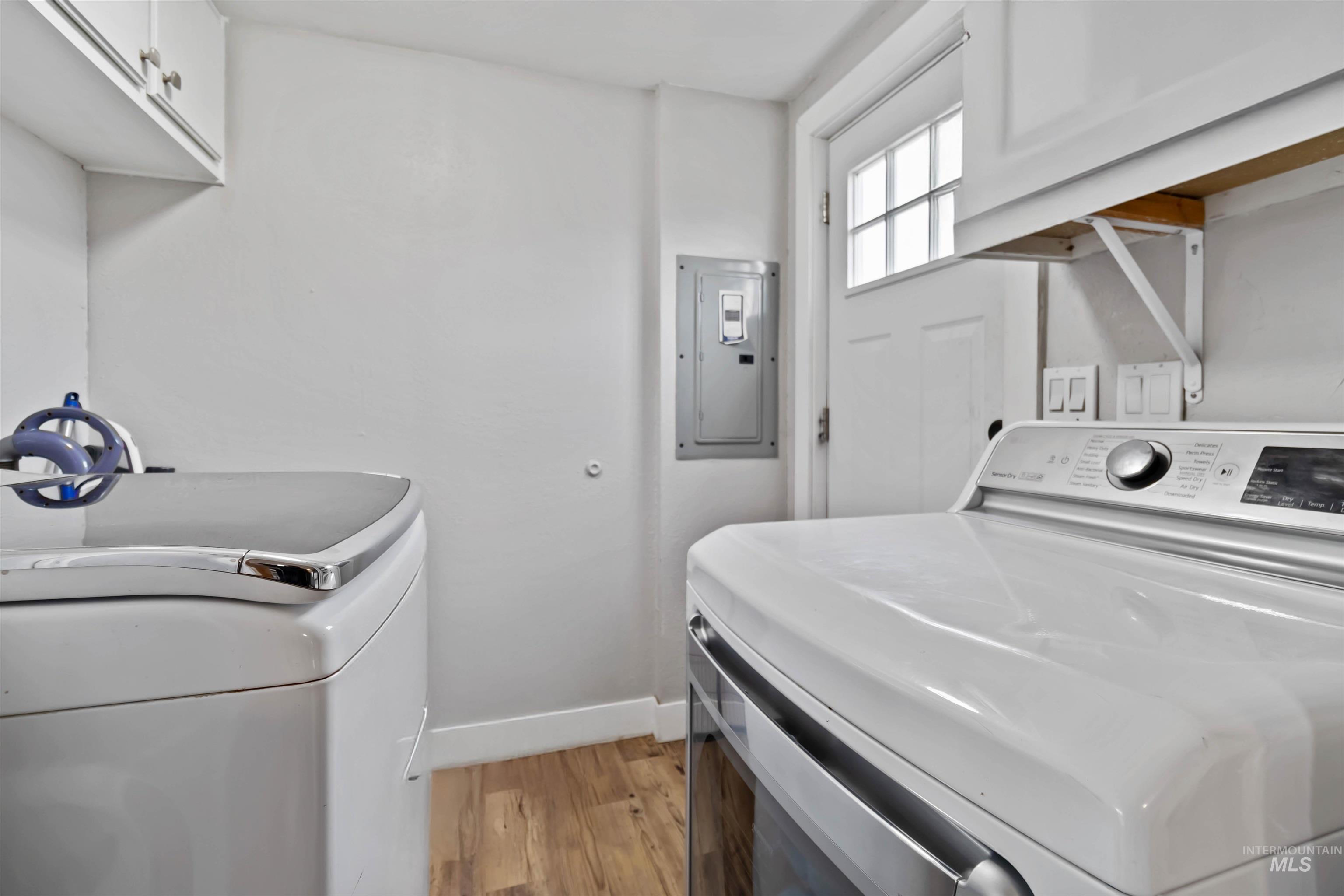 5827 East Little Basin Road King Hill, ID 83633 - Photo 20 of 47 Laundry room featuring electric panel, light wood-style floors, and washer and clothes dryer