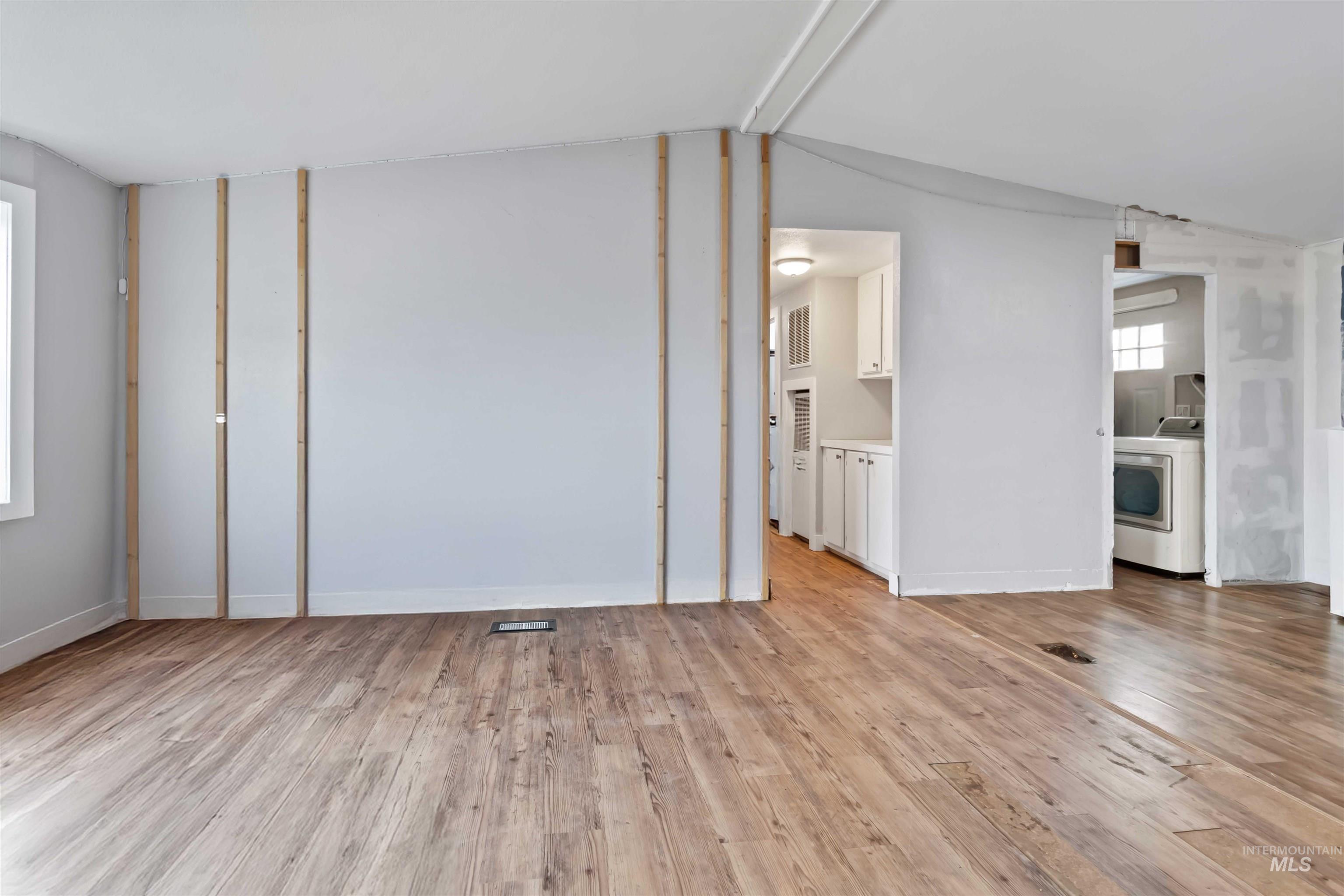 5827 East Little Basin Road King Hill, ID 83633 - Photo 21 of 47 Unfurnished living room with light wood-type flooring, washer / clothes dryer, and lofted ceiling