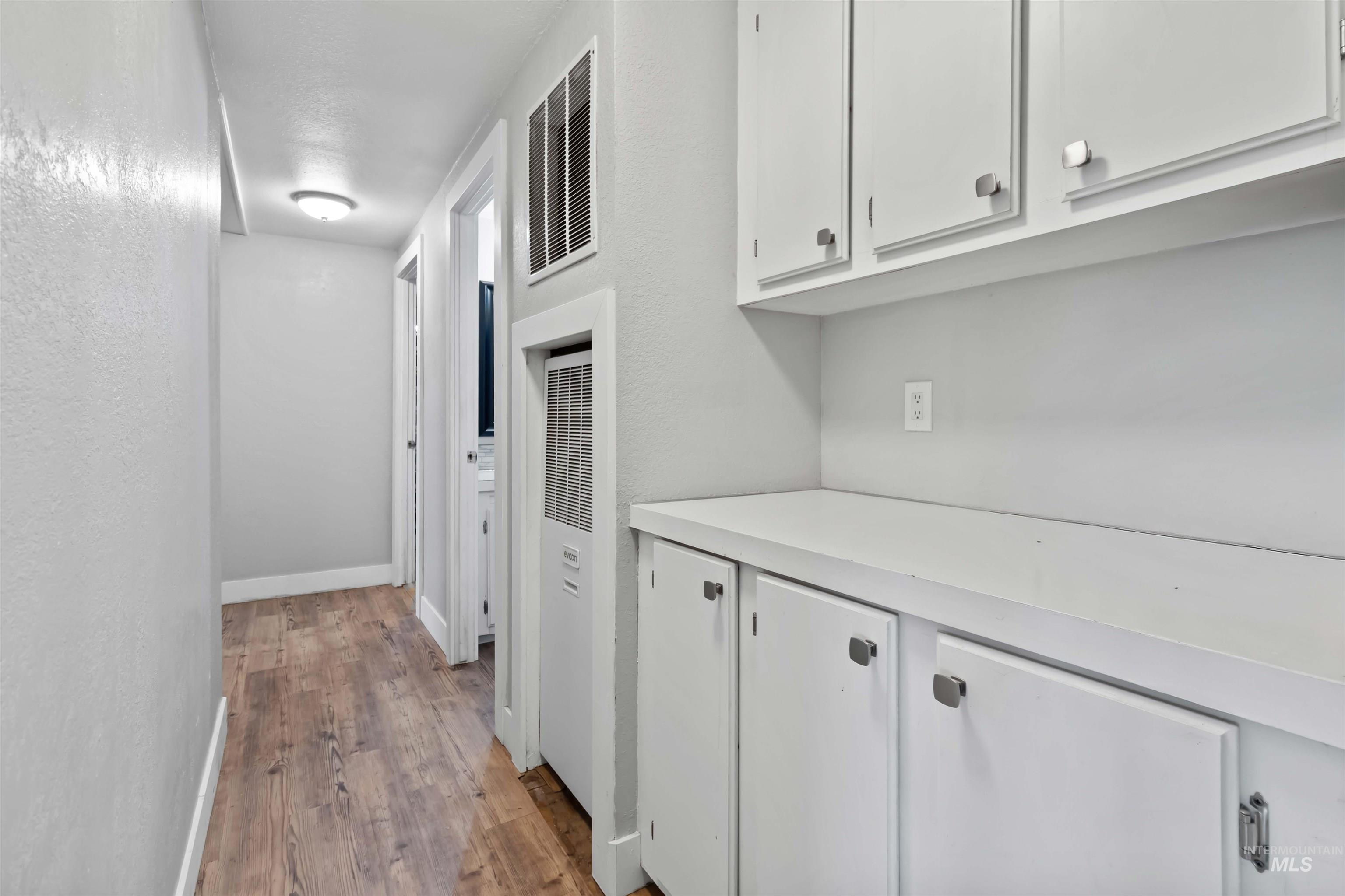 5827 East Little Basin Road King Hill, ID 83633 - Photo 22 of 47 Corridor with light wood-type flooring, a heating unit, and a textured wall