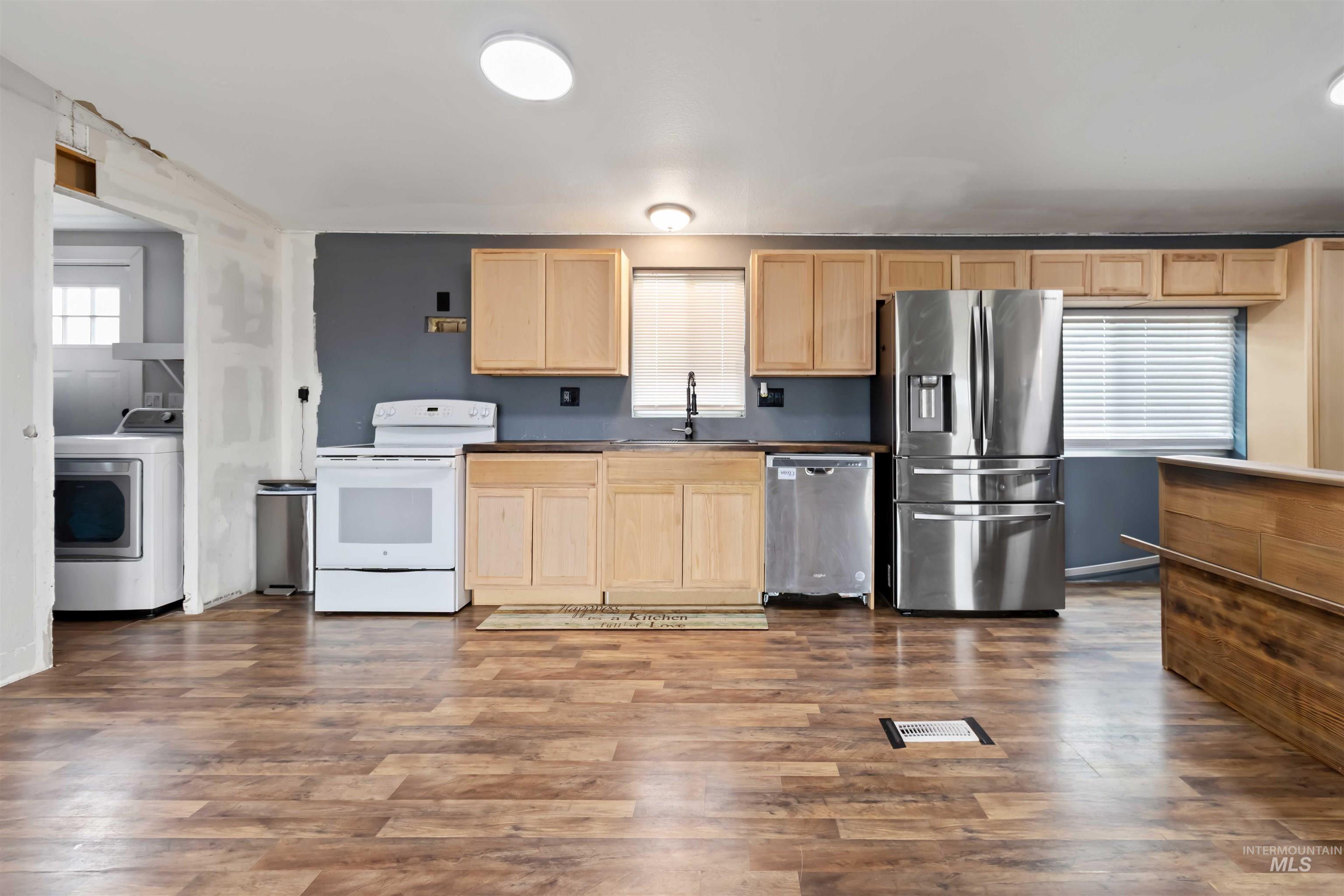 5827 East Little Basin Road King Hill, ID 83633 - Photo 6 of 47 Kitchen with light brown cabinets, stainless steel appliances, washer / dryer, dark wood-style floors, and dark countertops