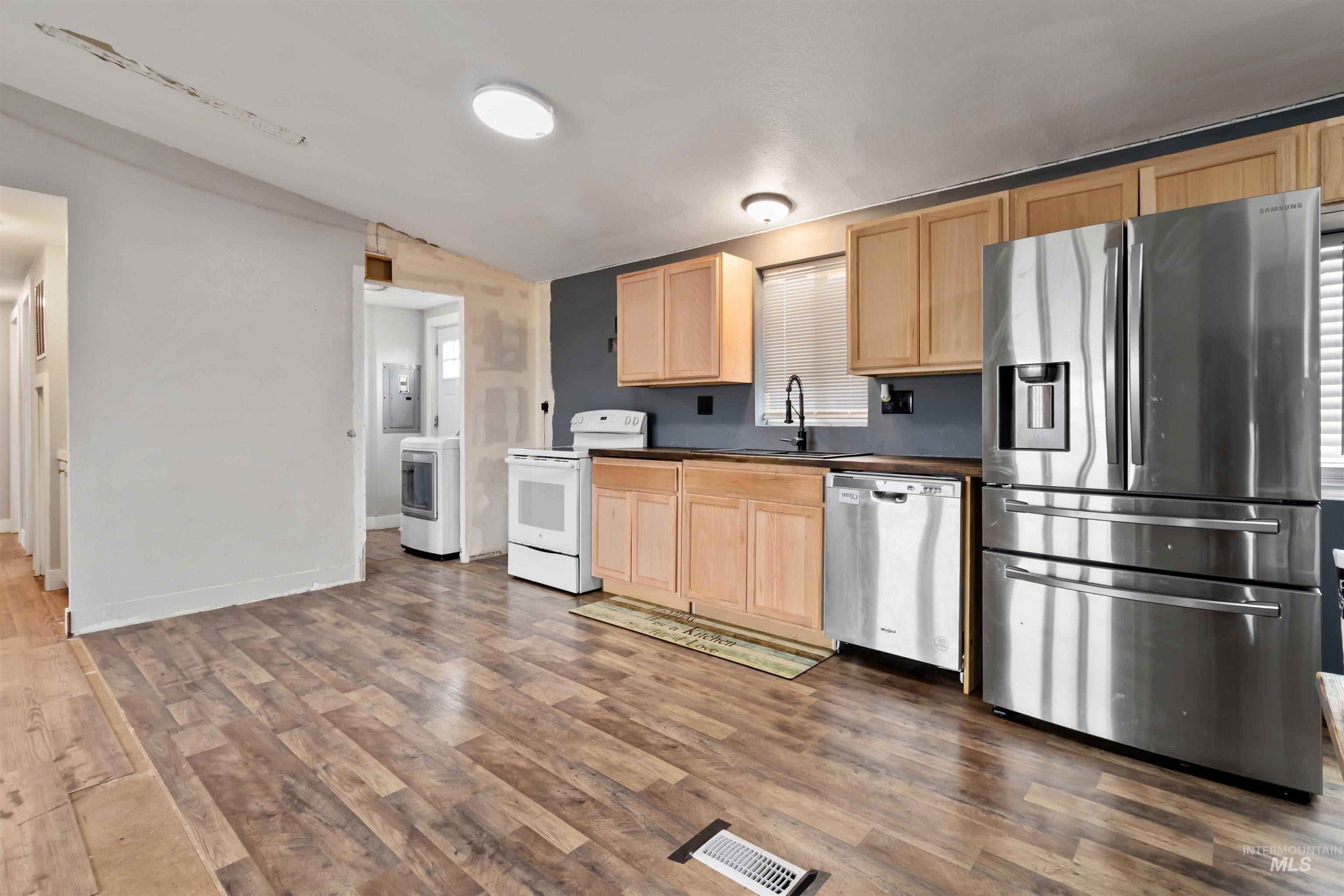 5827 East Little Basin Road King Hill, ID 83633 - Photo 7 of 47 Kitchen with light brown cabinets, stainless steel appliances, dark wood-style flooring, dark countertops, and vaulted ceiling