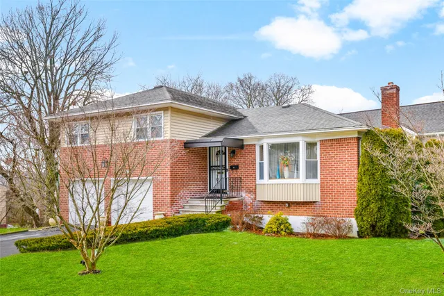 a front view of a house with a garden and plants