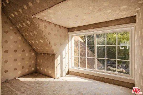 a view of an empty room with window and a kitchen