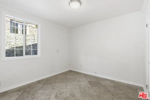a view of wooden floor in an empty room with a window