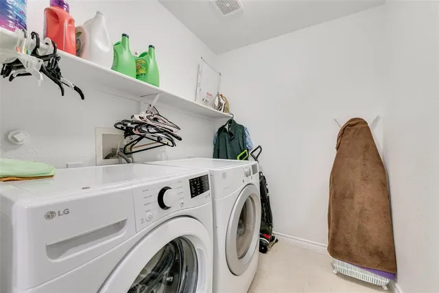 a view of washer and dryer with kitchen in the background