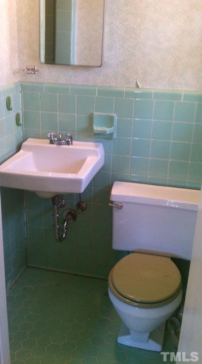 1007 Akron Avenue Durham, NC 27713 - Photo 5 of 8 a bathroom with a sink mirror and toilet