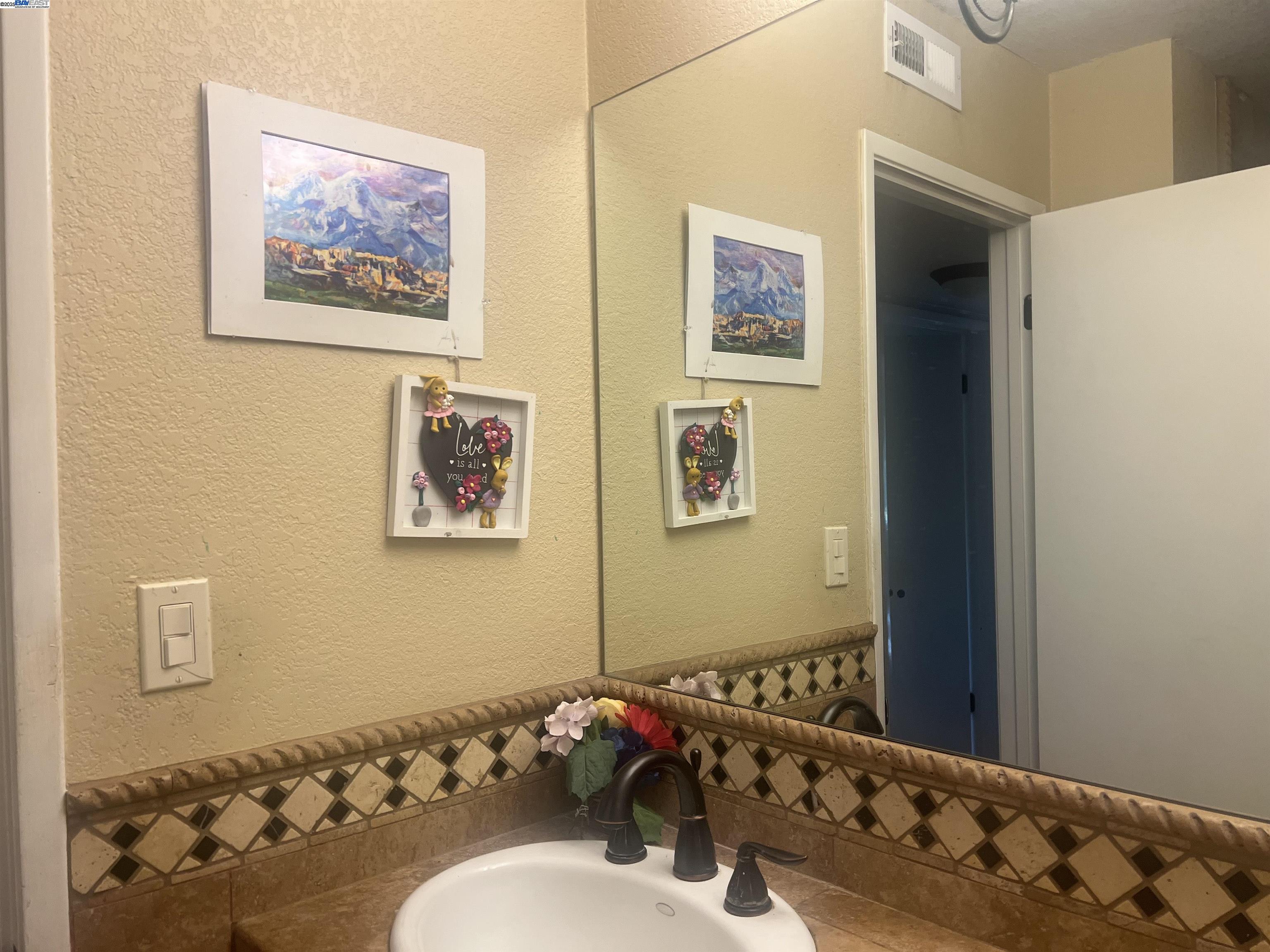 2155 Goldcrest Circle Pleasanton, CA 94566 - Photo 13 of 14 a bathroom with a sink and mirror with toilet