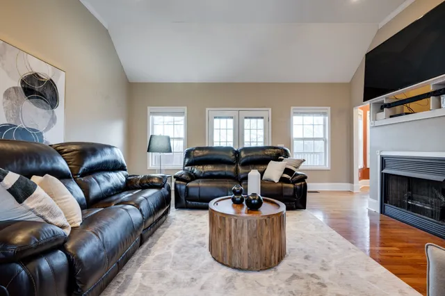 a living room with furniture a flat screen tv and a fireplace