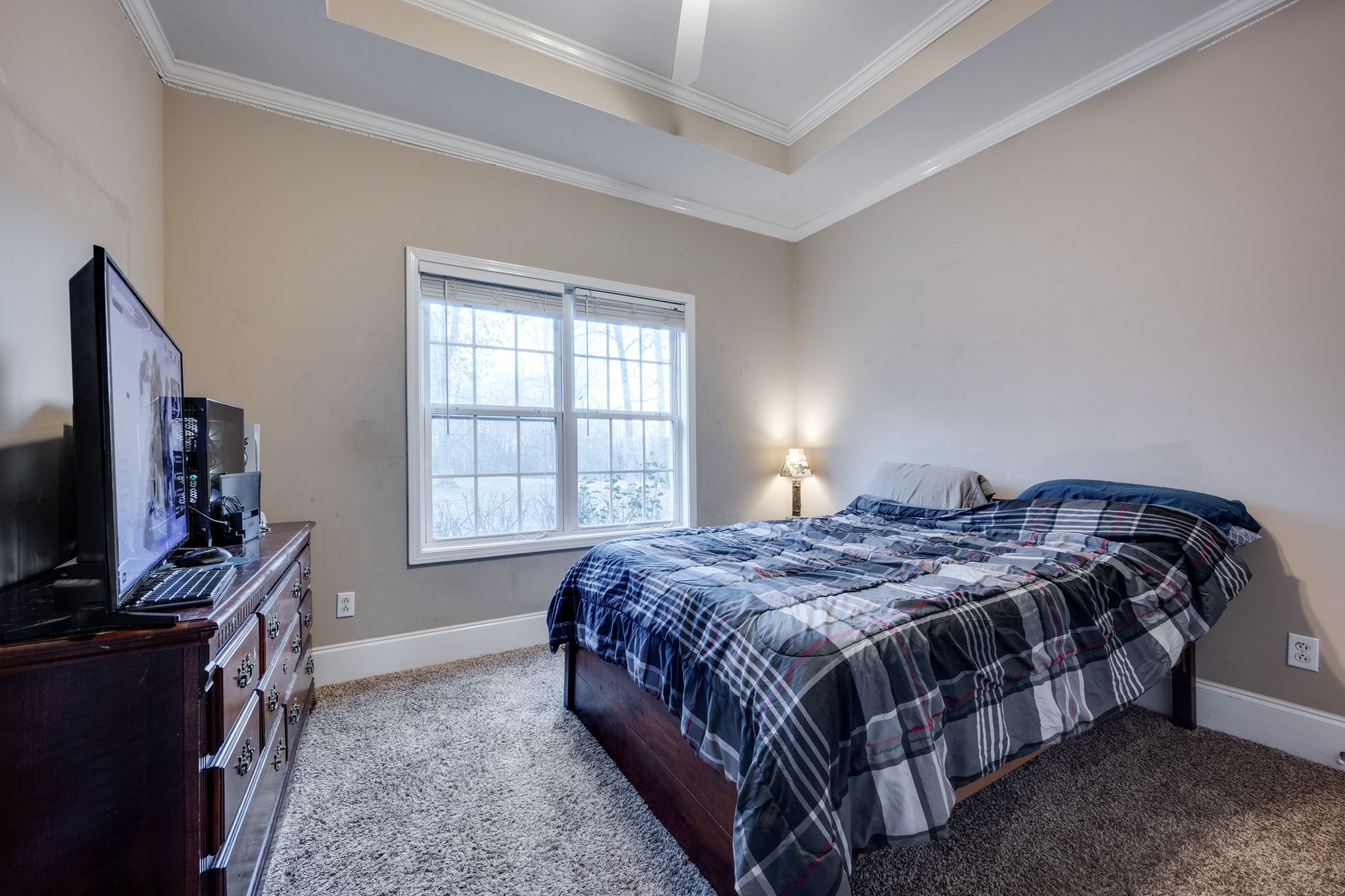 754 Hafner Road Charlotte, TN 37036 - Photo 29 of 54 a bedroom with a bed table flat screen tv and a window