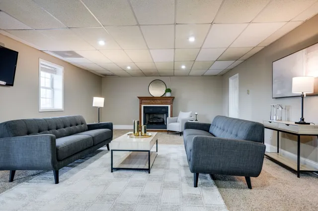 a living room with furniture and a baby crib