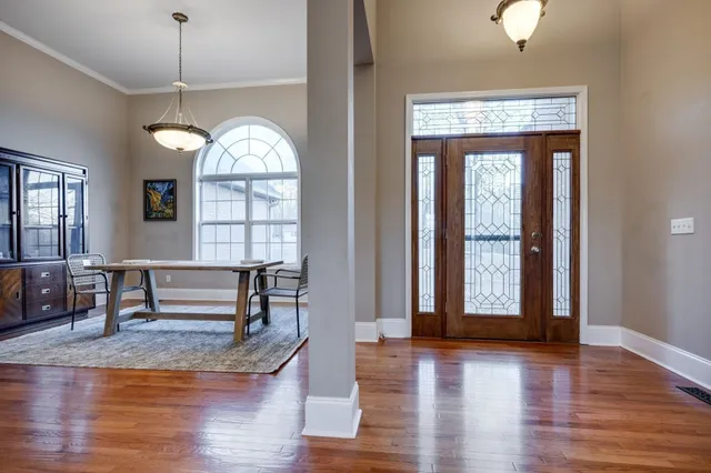 a view of an empty room with window and wooden floor