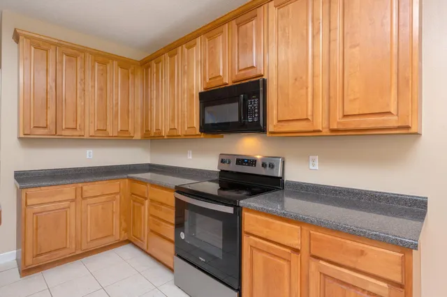 a kitchen with granite countertop cabinets stainless steel appliances granite counter tops and a wooden floors