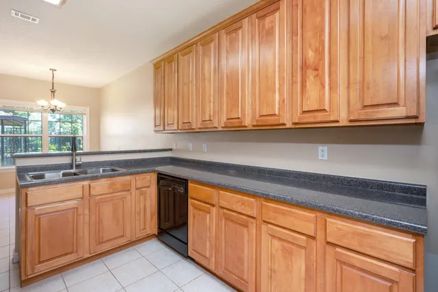 a kitchen with granite countertop white cabinets and sink
