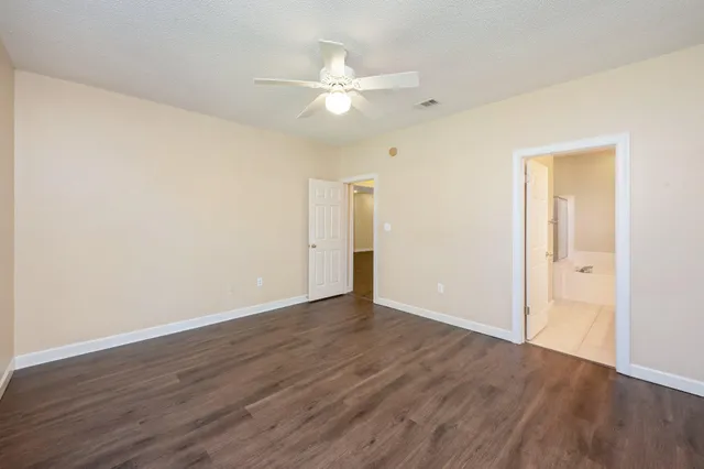 a view of an empty room with wooden floor