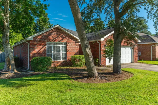 a front view of a house with yard and green space