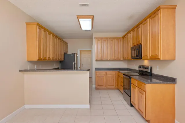 a kitchen with stainless steel appliances granite countertop a stove a sink a microwave and refrigerator