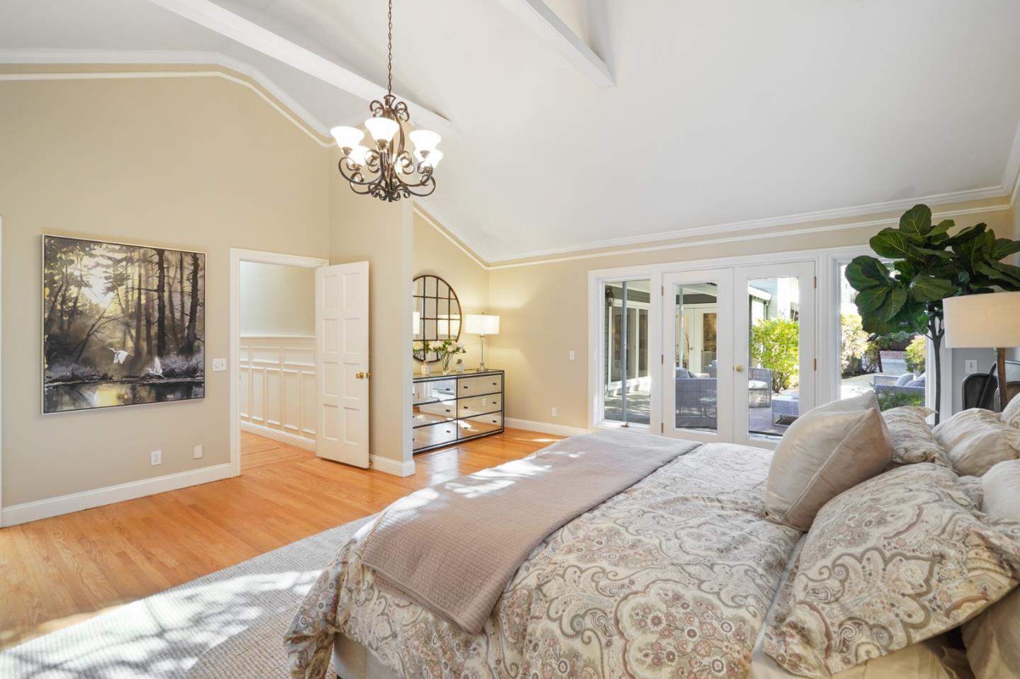 251 Gramercy Drive San Mateo, CA 94402 - Photo 28 of 40 a spacious bedroom with a bed a dresser and a chandelier