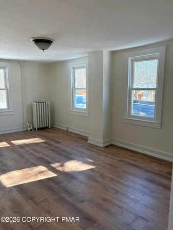 a view of a livingroom with wooden floor and a window
