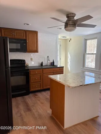 a view of a hallway to a bedroom with wooden floor and a bathroom