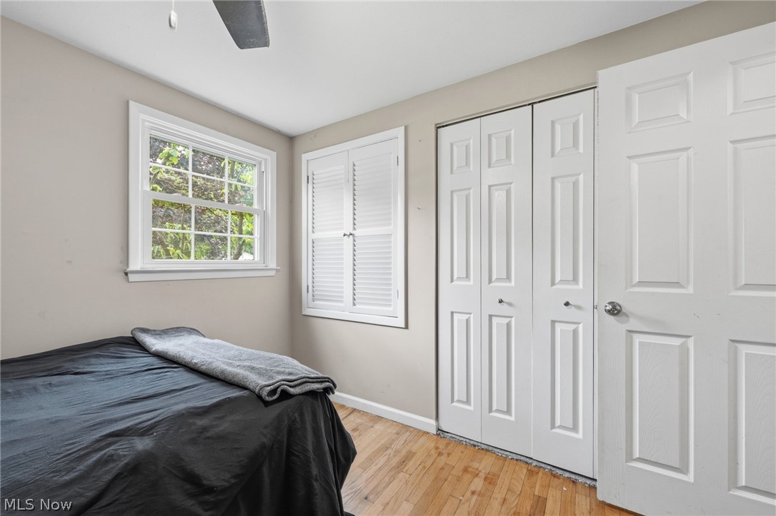 6472 Southgrove Road Mentor, OH 44060 - Photo 19 of 37 Bedroom featuring wood-finish flooring, a double-hung window, white plantation shutters, and a bi-fold closet door