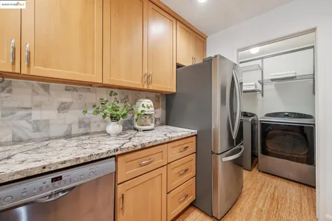 a kitchen with stainless steel appliances granite countertop a refrigerator sink and stove