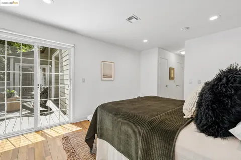 a bed sitting in a spacious bedroom next to a window