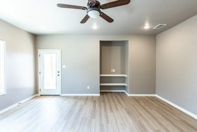 a view of empty room with wooden floor