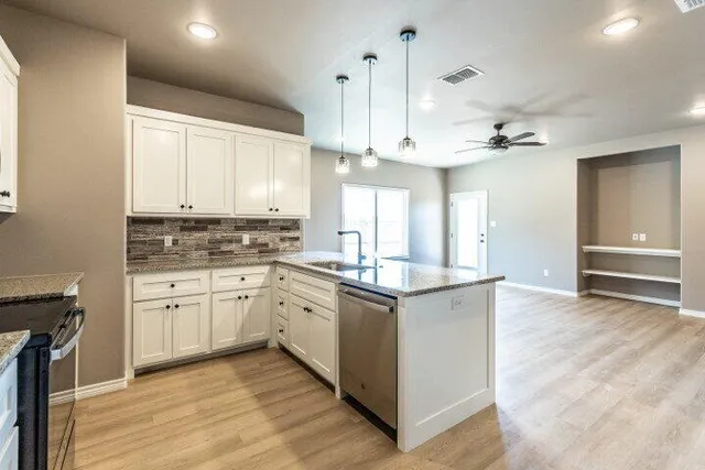 a kitchen with stainless steel appliances granite countertop a stove and cabinets