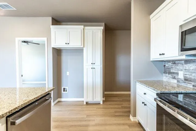 a kitchen with granite countertop a sink stove and cabinets