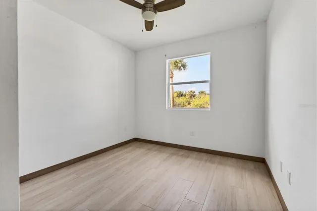 an empty room with a window and wooden floor