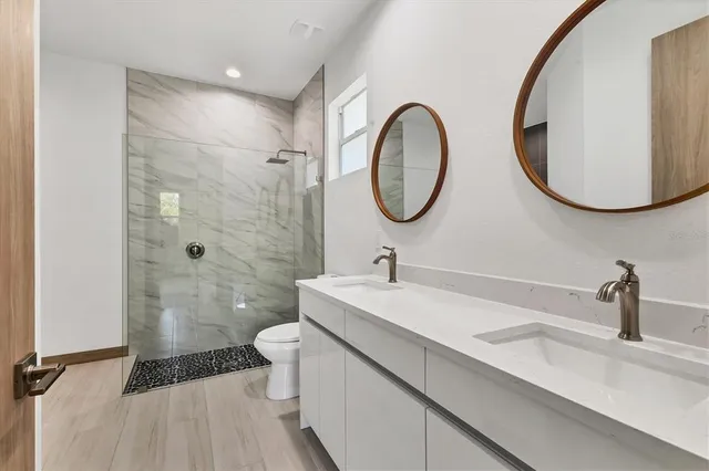 a bathroom with a sink a toilet and a mirror