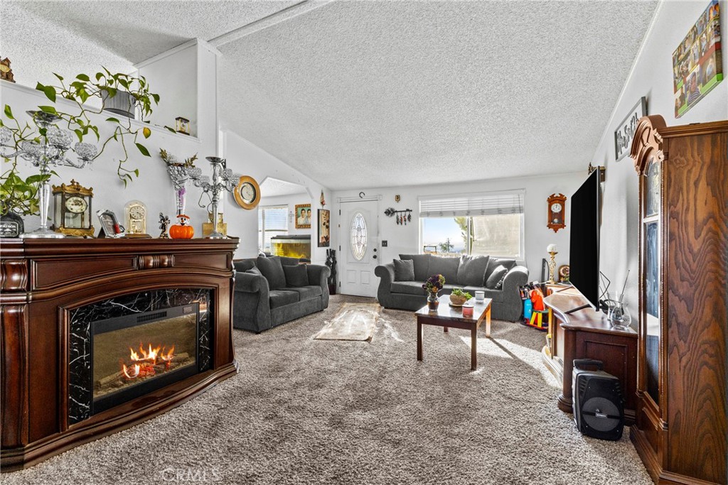 33945 Red Mountain Road Hemet, CA 92544 - Photo 3 of 30 a living room with furniture a flat screen tv and a fireplace