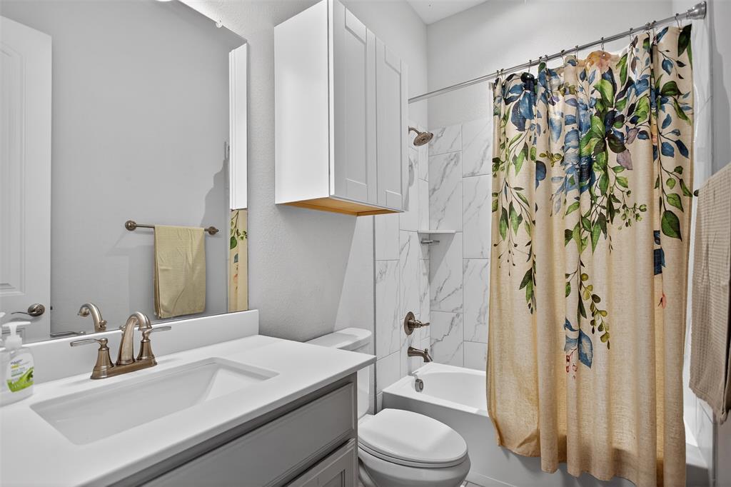 6829 Danridge Road Rowlett, TX 75089 - Photo 16 of 28 a bathroom with a sink toilet and shower