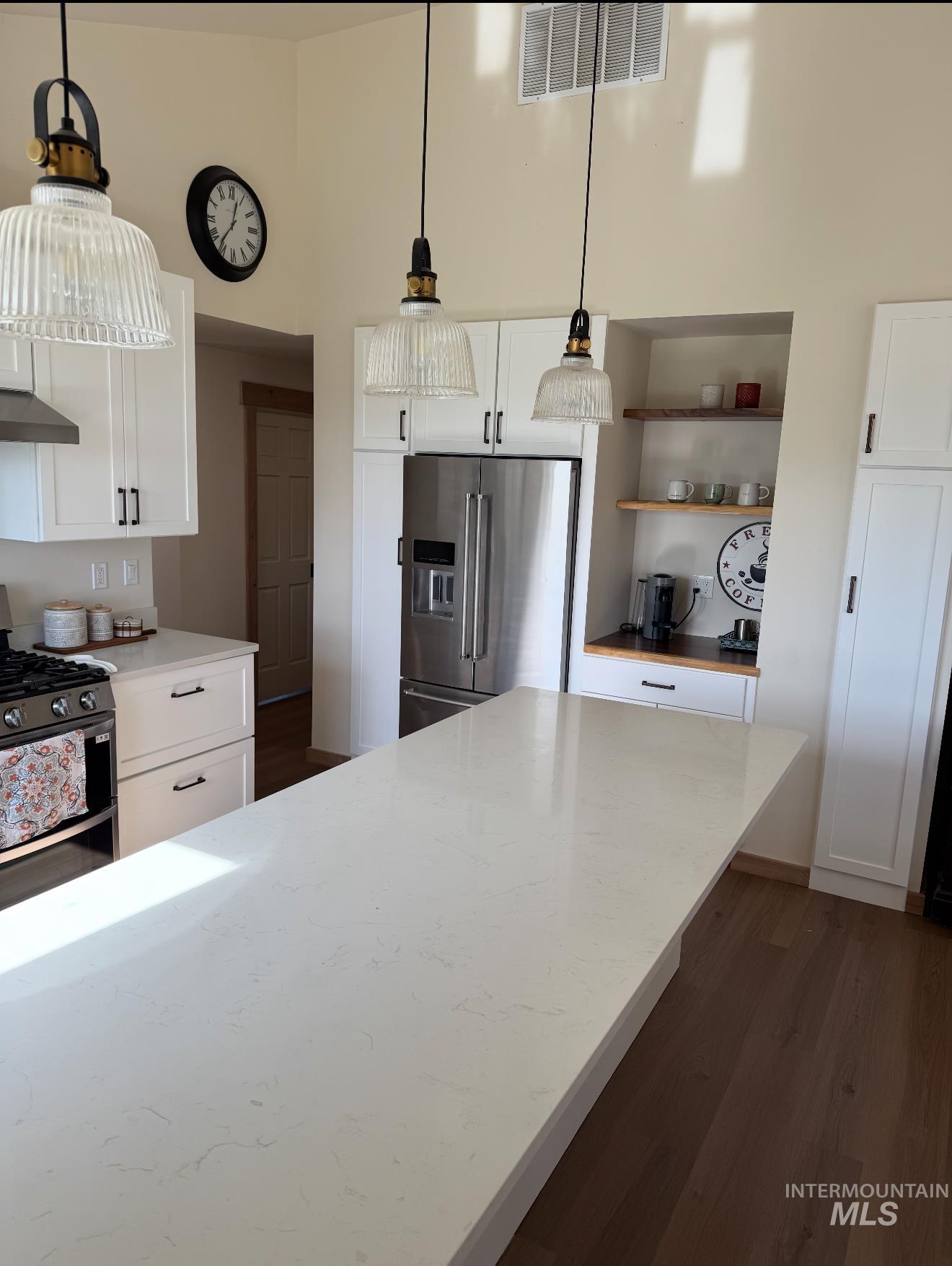 263 Glory Lane Orofino, ID 83544 - Photo 13 of 48 Kitchen featuring white cabinetry, stainless steel appliances, dark wood-type flooring, and a high ceiling