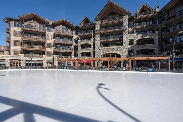 a front view of a building with glass windows and brick wall