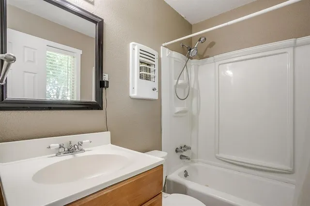 a bathroom with a sink a mirror toilet and bathtub