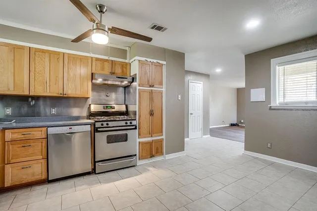 a kitchen with stainless steel appliances granite countertop a stove a sink and a refrigerator