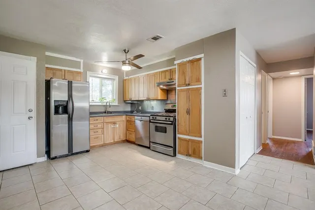 a kitchen with stainless steel appliances a refrigerator sink and cabinets
