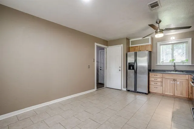 a view of a kitchen with a sink and refrigerator