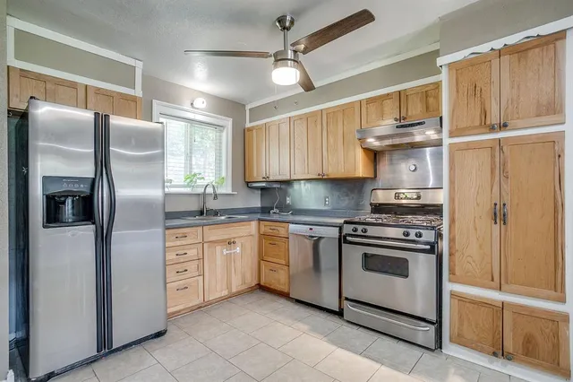 a modern kitchen with stainless steel appliances granite countertop a refrigerator and a sink